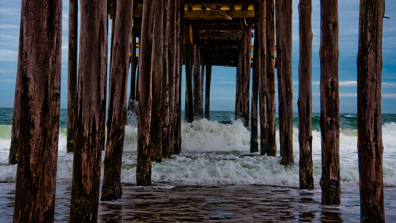 waves crashing under pier
